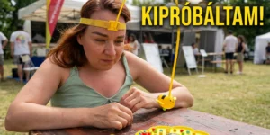 A műsorvezető fejre rögzített eszközzel és koncentrált tekintettel asztali érzékenyítő feladatot végez egy sárga méhecskés játéktáblán a balatonboglári fesztiválon, a képen a „KIPRÓBÁLTAM!” felirattal.