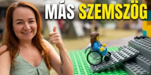 Mosolygó műsorvezető felemelt hüvelykujjal egy színes legóból épített akadálymentes rámpa és kerekesszék mellett, a kép felső részén a „MÁS SZEMSZÖG” felirattal.